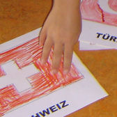 Kinderhand mit selbst gemalter Flagge;  (BIBER) Schulen ans Netz